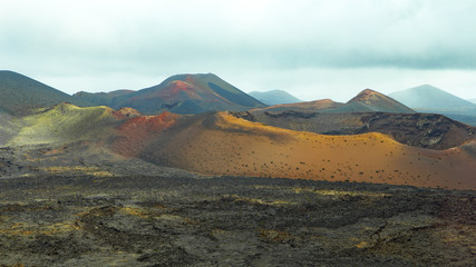 Fototapeta na wymiar colrorful volcanic landscape with a big crater and lava field in the foreground