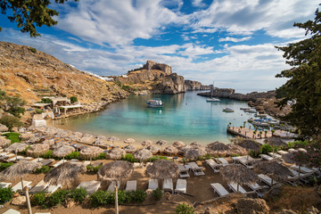 St. Paul bay with boats, Lindos acropolis in background (Rhodes, Greece).
