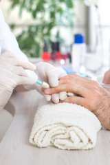 Obraz premium Męskie dłonie podczas zabiegu manicure w salonie kosmetycznym. 