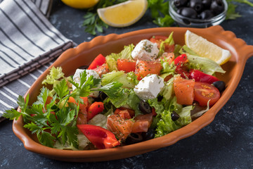 Salmon with vegetables,  cheese and  black olives. Diet food in a plate.  Closeup