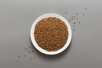 Buckwheat cereal grains on the grey background, top view, flat lay
