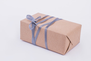 Brown gift box isolated on gray background. Vintage paper present box with ribbon. Handmade present for Holiday.