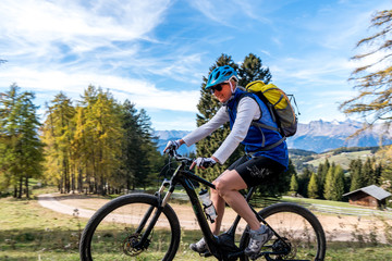 Fototapeta na wymiar Fröhliche Frau mittleren Alters auf einem E-Mountainbike