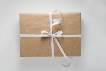 Wrapped gift box on white wooden background, top view. Filter effect