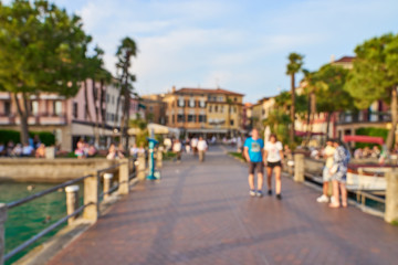 Blurred background picture of tourists on a walkway in Sirmione at Lake Garda in Italy