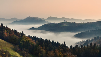 Foggy mountain landscape at dawn. Autumn scenery. Slovenia Sveti Tomaž from hill. sunrise