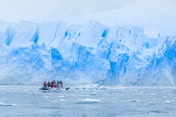 Foto op Canvas Sneeuwval over boot met toeristen in de baai vol ijsbergen met enorme gletsjermuur op de achtergrond, in de buurt van Almirante Brown, Antarctisch schiereiland © vadim.nefedov