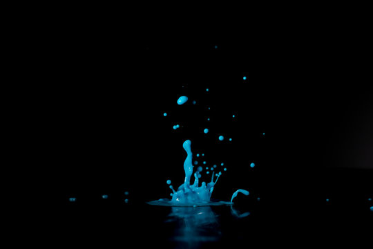 Blue paint, ink splash on black background