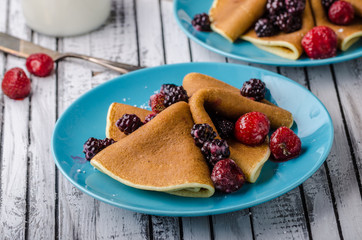 Homemade crepes with frozen berries, topped sugar
