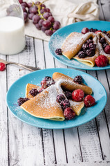 Homemade crepes with frozen berries, topped sugar