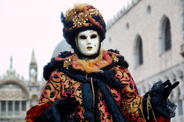 Fototapeta na wymiar Carnival black-gold mask and costume at the traditional festival in Venice, Italy