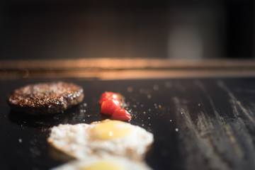 Cutlets from minced meat roasted on the grill. chicken eggs and tomatoes on the grill. breakfast in restaurant
