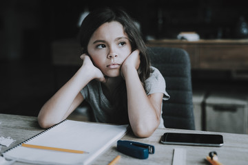 Little Girl Sits at Desk Shows Bored Expression