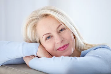 Foto op Aluminium Active beautiful middle-aged woman smiling friendly and looking in camera. Woman's face closeup. Realistic images without retouching with their own imperfections. Selective focus. © missty