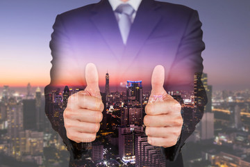 Double exposure of businessman give a two thumbs up for compliment and cityscape in the night or twilight as business, praise, congratulate, good and like concept - obrazy, fototapety, plakaty