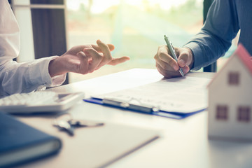 Real estate agent hand showing customer where to writing sign a contract of house or mortgage...