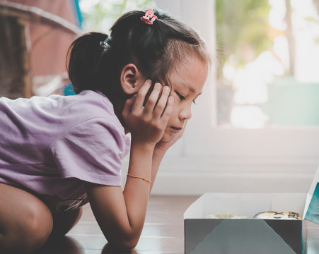 Little Girl Is Looking At Box Of Donut Wonder If She Should Eat It