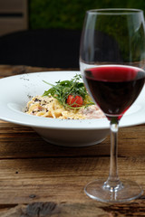 Glass of red wine and cheese pasta