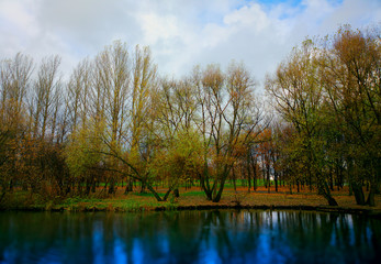 Fototapeta na wymiar Autumn trees on park river bank background