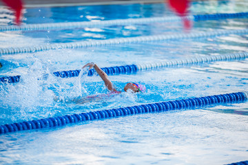 Athlete kid swimming in backstroke competition