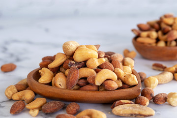 Fototapeta na wymiar roasted mixed nuts in wooden bowl on barble table background.