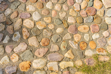 Texture of multi-colored smooth stones connected by concrete