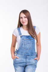 Portrait of a smiling pretty woman in denim overall isolated on white background