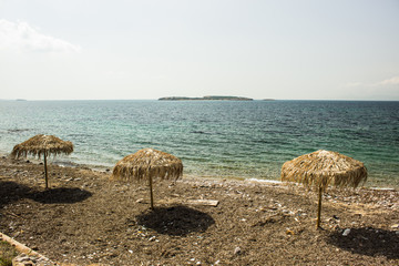 Fototapeta na wymiar vacation concept straw umbrella on coast of south sea