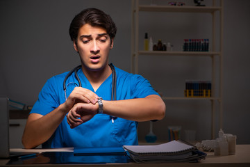 Young handsome doctor working night shift in hospital   