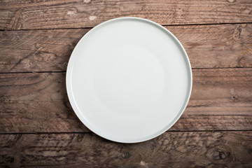 Empty dish on wood background. Top view.