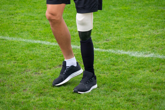 Close up disabled man athlete with leg prosthesis. Paralympic Sport Concept. - Powered by Adobe