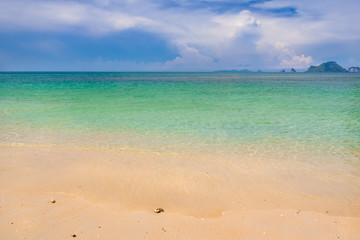 Fototapeta na wymiar Beach sand and blue sea with blue sky