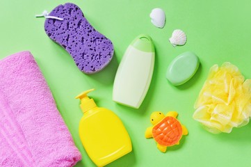 Flat lay baby bath products. Shampoo, liquid soap, accessories and rubber toy. Top view toiletries