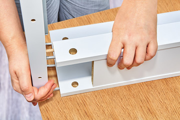 Furniture assembler connects parts of table, flat pack furniture assembly.