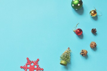 Christmas tree, colorful baubles, pine cones, snowflake on a blue background. Flat lay New Year decoration
