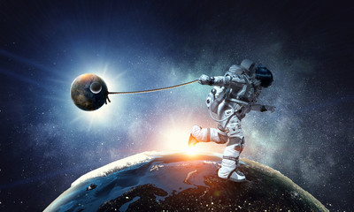 Fototapeta na wymiar Spaceman steal planet. Mixed media