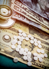  stethoscope on American tickets along with a boat of white pills