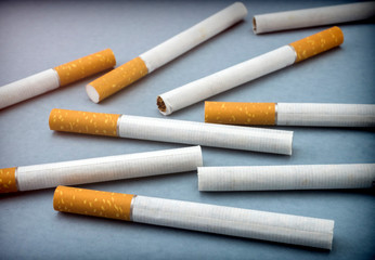 Some cigarettes isolated on a blue background, conceptual image