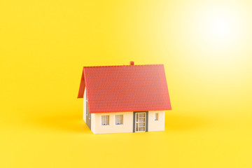 Modell eines Einfamilienhaus mit gelben Hintergrund