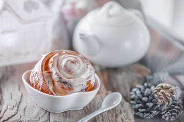 Delicious homemade sweet buns with cinnamon and icing sugar Christmas at the old wooden table. Traditional Swedish pastries, kanelbullar
