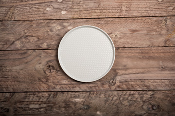 Empty dish on wood background. Top view.