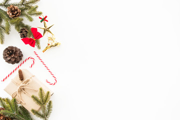 Gift boxes with pine branches and pine cones are on top of white desk table during Christmas or new year. Top view with copy space, flat lay.