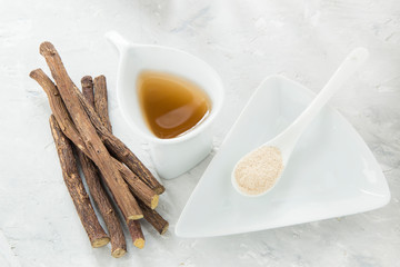 Obraz na płótnie Canvas Licorice tea, powder and roots on the table
