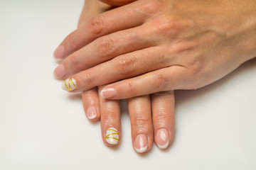French manicure and nail gel Polish. The decoration of the nail white and gold decor. Top view Close-up photography