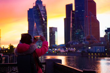 Happy time of young man tourist which taking a picture by smart phone in the ctyscape of Building at Moscow,Russia