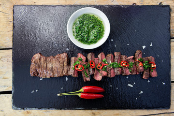 Black stone plate with skirt steak pepper and chimichurri sauce