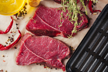 Fresh raw beef meat steak slices with spices and olive oil ready for cooking