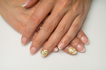 French manicure and nail gel Polish. The decoration of the nail white and gold decor. Top view Close-up photography