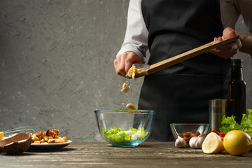 Freezing food is cooked in the process, quail eggs are poured out by the chef of a vegetarian salad with seafood. The backdrop is a concrete wall with a text area
