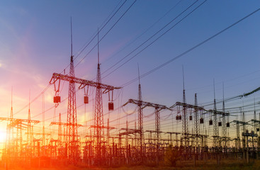 high-voltage power lines at sunset. electricity distribution station .